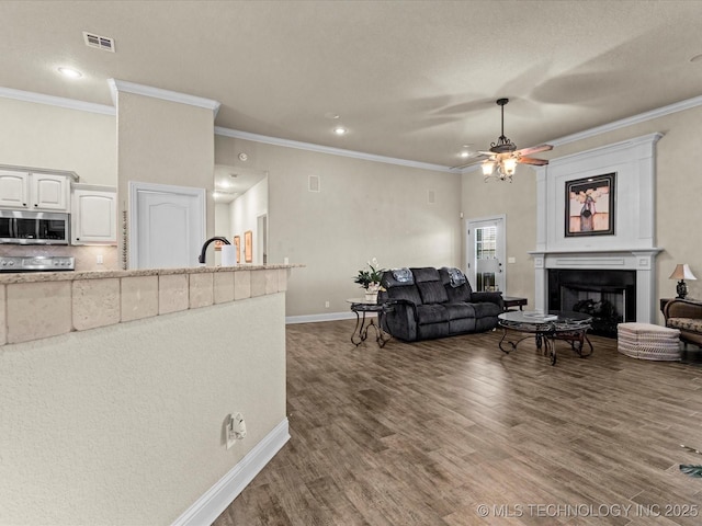 5719 Nottingham Pl, Bartlesville, OK 74006 - living room with wood finished floors, crown molding, ceiling fan, recessed lighting, and a fireplace