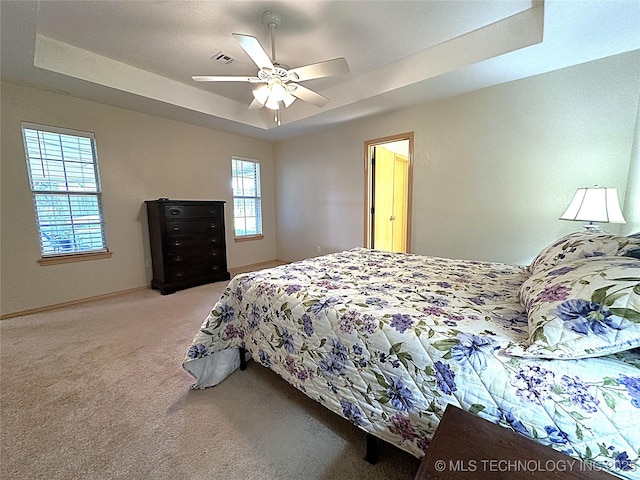1530 Persimmon, Ardmore, OK 73401 - bedroom featuring a tray ceiling, light carpet, and a ceiling fan