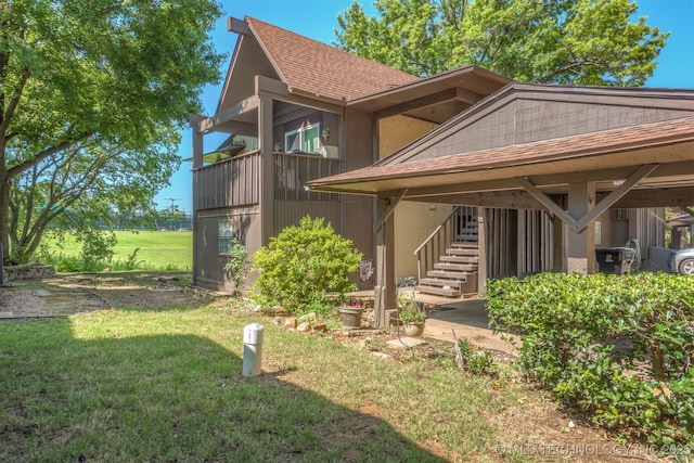 15917 E 131st St Unit 93, Broken Arrow, OK 74011 - rear view of property featuring stairway, a shingled roof, and a yard