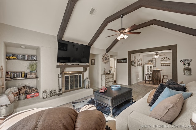 15917 E 131st St Unit 93, Broken Arrow, OK 74011 - living room featuring ceiling fan, high vaulted ceiling, beamed ceiling, wood finished floors, and a glass covered fireplace