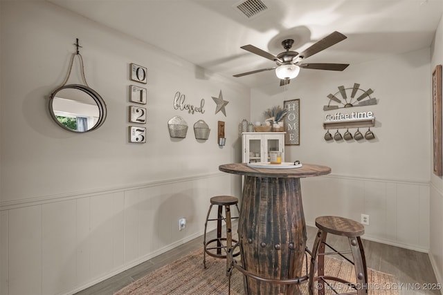 15917 E 131st St Unit 93, Broken Arrow, OK 74011 - bar featuring wood finished floors, wainscoting, ceiling fan, and a decorative wall