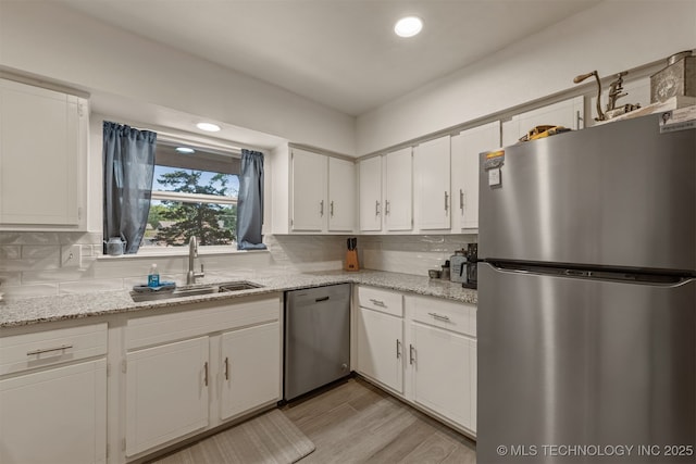15917 E 131st St Unit 93, Broken Arrow, OK 74011 - kitchen with stainless steel appliances, white cabinetry, backsplash, light wood-type flooring, and light stone counters