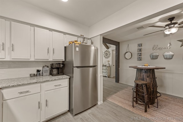 15917 E 131st St Unit 93, Broken Arrow, OK 74011 - kitchen with freestanding refrigerator, white cabinetry, light wood-style floors, a ceiling fan, and backsplash