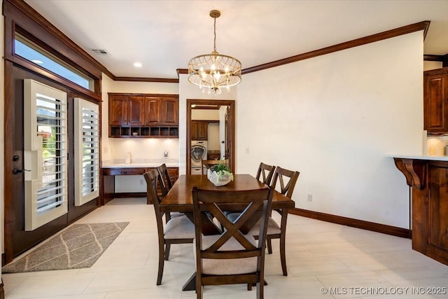 6797 Hummingbird Ct, Owasso, OK 74055 - dining area featuring washer / dryer, ornamental molding, and a chandelier