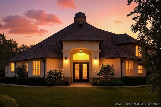 6797 Hummingbird Ct, Owasso, OK 74055 - entrance to property with a lawn, stucco siding, stone siding, and a chimney