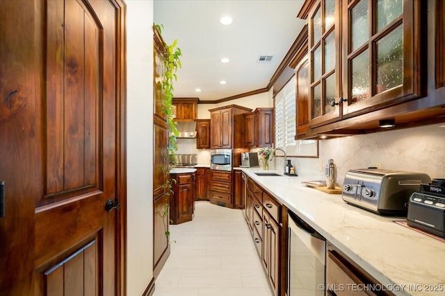 6797 Hummingbird Ct, Owasso, OK 74055 - kitchen featuring stainless steel appliances, light stone countertops, crown molding, recessed lighting, and glass insert cabinets