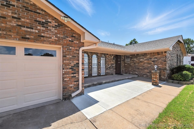 6627 Castle Ct, Bartlesville, OK 74006 - doorway to property featuring brick siding, roof with shingles, and a garage