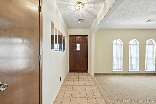 6627 Castle Ct, Bartlesville, OK 74006 - foyer entrance with a textured ceiling, light tile patterned floors, and light carpet