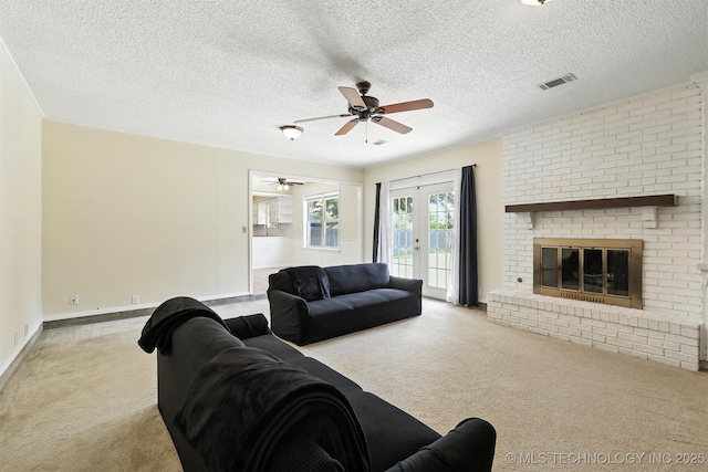 6627 Castle Ct, Bartlesville, OK 74006 - living area featuring carpet, a ceiling fan, a brick fireplace, french doors, and a textured ceiling
