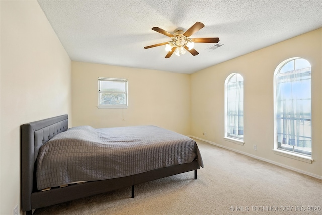 6627 Castle Ct, Bartlesville, OK 74006 - carpeted bedroom featuring multiple windows, a ceiling fan, and a textured ceiling