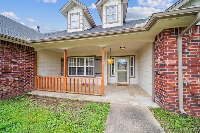 1018 W Evergreen St, Skiatook, OK 74070 - doorway to property featuring a porch, roof with shingles, and brick siding