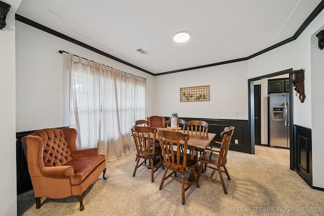 1018 W Evergreen St, Skiatook, OK 74070 - dining area featuring ornamental molding, light carpet, and wainscoting