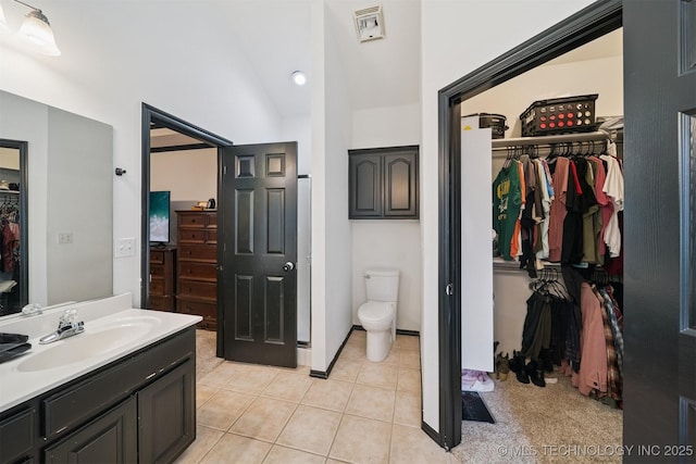 1018 W Evergreen St, Skiatook, OK 74070 - full bathroom with vanity, a spacious closet, vaulted ceiling, and tile patterned floors