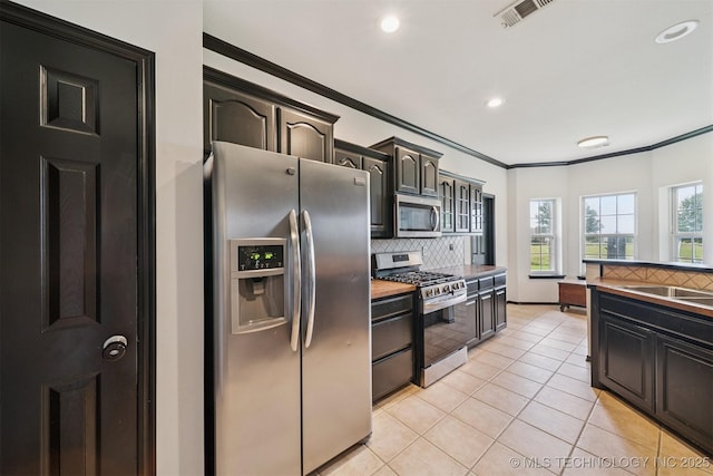 1018 W Evergreen St, Skiatook, OK 74070 - kitchen featuring stainless steel appliances, backsplash, ornamental molding, light tile patterned flooring, and recessed lighting