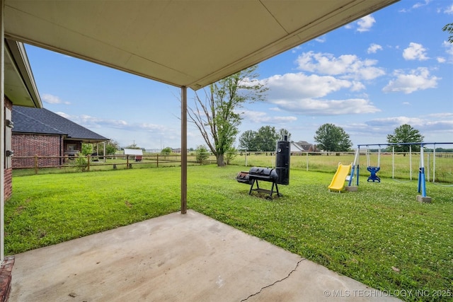 1018 W Evergreen St, Skiatook, OK 74070 - fenced backyard featuring a playground and a patio area