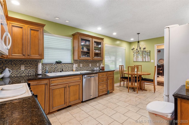 11420 S Mingo Rd, Bixby, OK 74008 - kitchen with stainless steel dishwasher, freestanding refrigerator, brown cabinets, a textured ceiling, and decorative backsplash