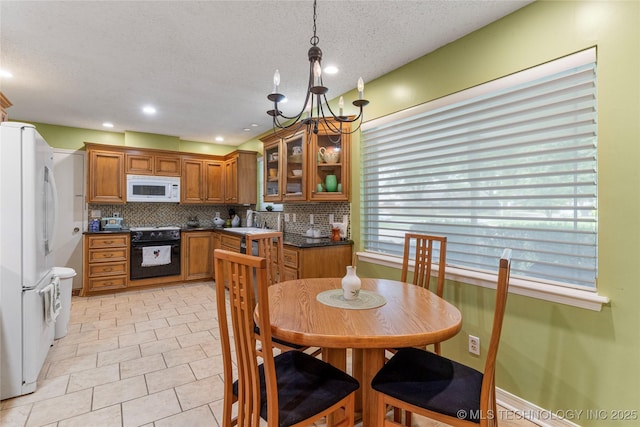 11420 S Mingo Rd, Bixby, OK 74008 - kitchen featuring white appliances, brown cabinets, dark countertops, tasteful backsplash, and a chandelier