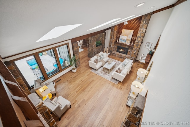 12526 S 12th St, Jenks, OK 74037 - living room featuring wood finished floors, a stone fireplace, a skylight, recessed lighting, and lofted ceiling