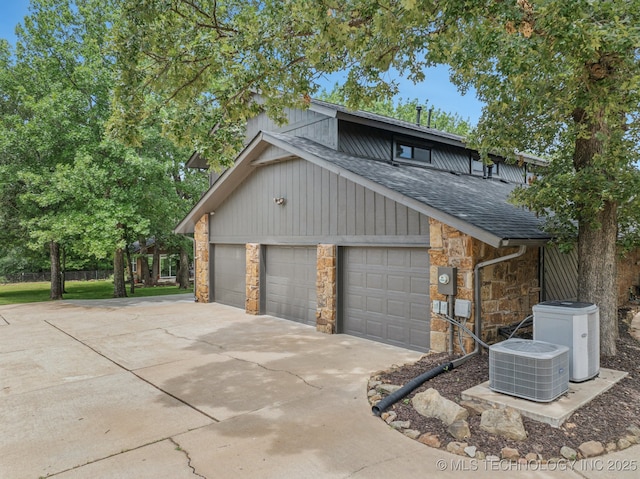 12526 S 12th St, Jenks, OK 74037 - view of side of home featuring stone siding, roof with shingles, driveway, and a garage