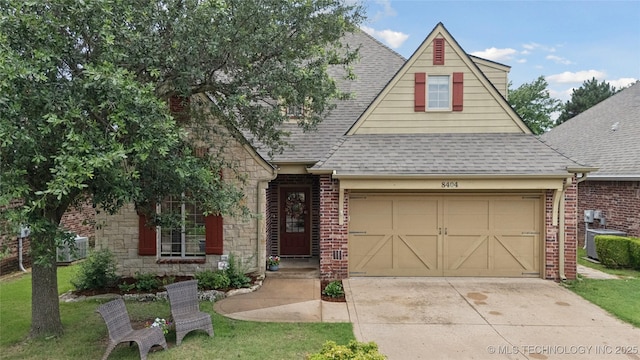 8404 E 98th Pl, Tulsa, OK 74133 - view of front of house featuring a shingled roof, an attached garage, concrete driveway, and brick siding
