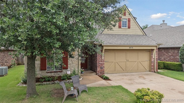 8404 E 98th Pl, Tulsa, OK 74133 - view of front of home with roof with shingles, concrete driveway, a front lawn, and brick siding