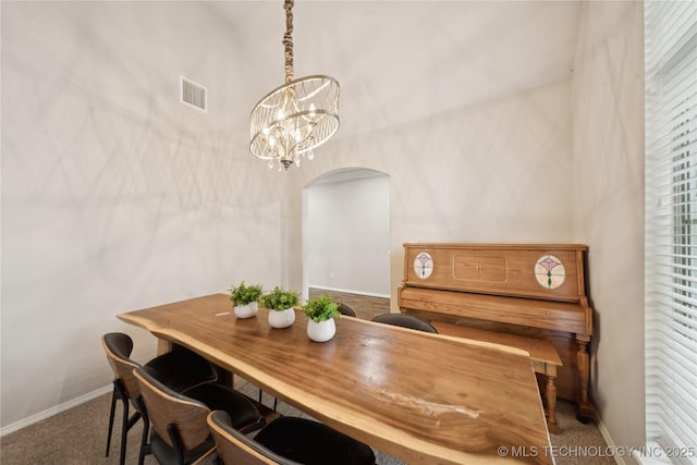 8404 E 98th Pl, Tulsa, OK 74133 - carpeted dining room with arched walkways and a chandelier