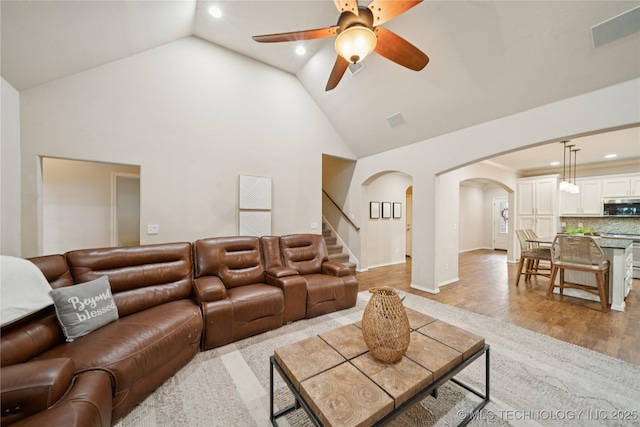 8404 E 98th Pl, Tulsa, OK 74133 - living room featuring arched walkways, recessed lighting, high vaulted ceiling, ceiling fan, and stairway