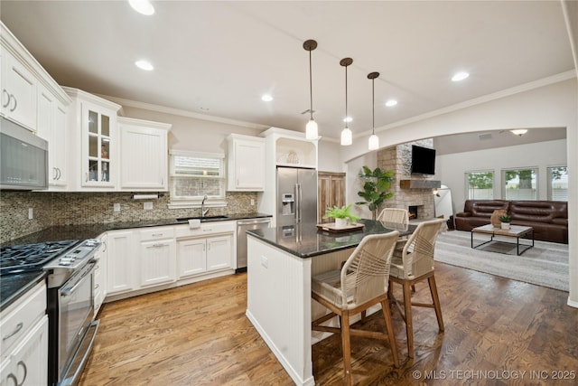 8404 E 98th Pl, Tulsa, OK 74133 - kitchen featuring appliances with stainless steel finishes, white cabinetry, tasteful backsplash, a breakfast bar, and crown molding
