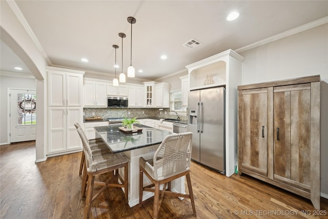 8404 E 98th Pl, Tulsa, OK 74133 - kitchen featuring stainless steel appliances, crown molding, white cabinets, a kitchen island, and backsplash