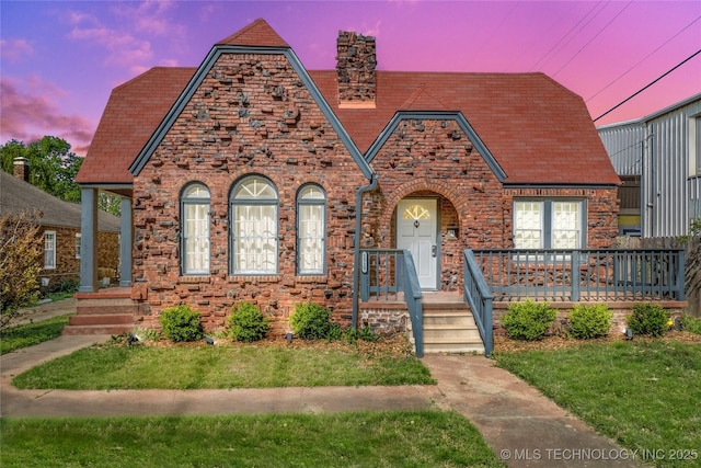 1510 S College Ave, Tulsa, OK 74104 - tudor home with a chimney, a lawn, and brick siding