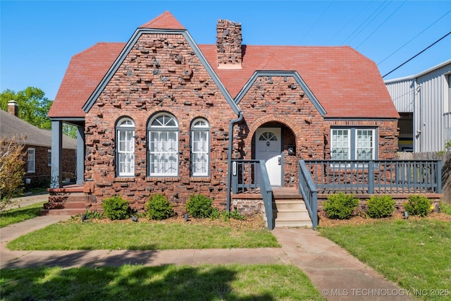 1510 S College Ave, Tulsa, OK 74104 - tudor home with a chimney, a high end roof, brick siding, a front yard, and stone siding