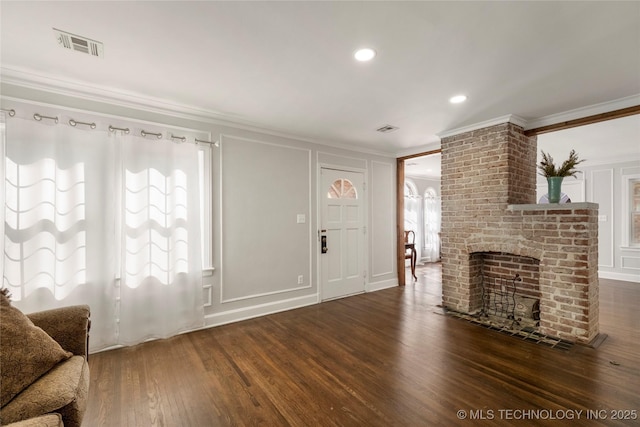 1510 S College Ave, Tulsa, OK 74104 - unfurnished living room featuring a decorative wall, crown molding, dark wood finished floors, a fireplace, and recessed lighting