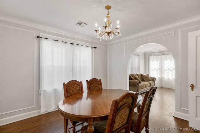 1510 S College Ave, Tulsa, OK 74104 - dining space with arched walkways, a chandelier, dark wood-style flooring, and ornamental molding