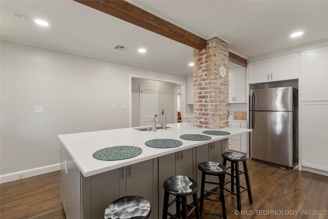 1510 S College Ave, Tulsa, OK 74104 - kitchen featuring freestanding refrigerator, decorative columns, dark wood-style floors, white cabinetry, and light countertops