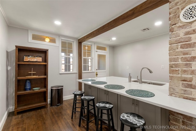 1510 S College Ave, Tulsa, OK 74104 - kitchen featuring dark wood-type flooring, a breakfast bar, light countertops, a peninsula, and recessed lighting