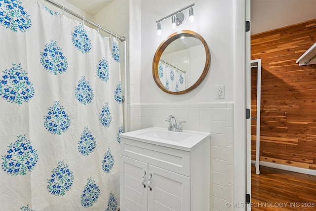 10 E 31st Pl, Sand Springs, OK 74063 - bathroom with vanity, tile walls, wood finished floors, wood walls, and a shower with curtain
