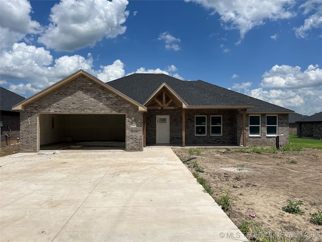 3102 Larkspur Ln, Durant, OK 74701 - view of front facade featuring brick siding, concrete driveway, a garage, and roof with shingles
