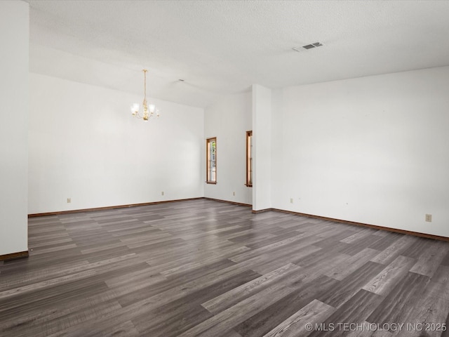 317 NE Autumn Ct, Bartlesville, OK 74006 - unfurnished room featuring a chandelier, wood finished floors, vaulted ceiling, and a textured ceiling