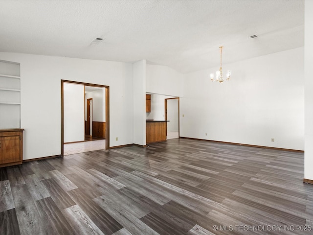 317 NE Autumn Ct, Bartlesville, OK 74006 - unfurnished room with a chandelier, dark wood-style floors, and a textured ceiling