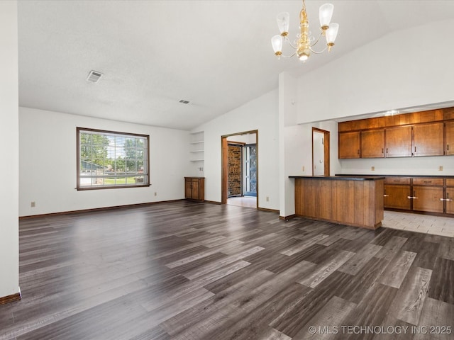 317 NE Autumn Ct, Bartlesville, OK 74006 - unfurnished living room featuring dark wood finished floors, a chandelier, and high vaulted ceiling
