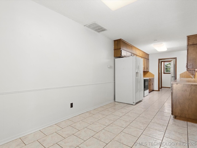 317 NE Autumn Ct, Bartlesville, OK 74006 - kitchen featuring white appliances, light countertops, and light tile patterned floors