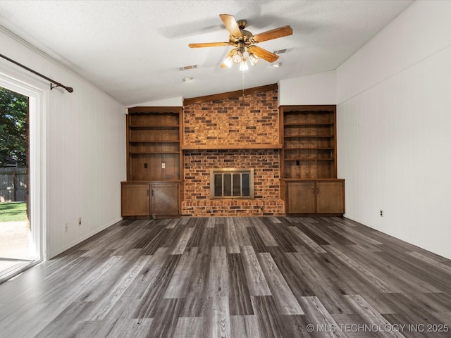 317 NE Autumn Ct, Bartlesville, OK 74006 - unfurnished living room featuring vaulted ceiling, wood finished floors, a brick fireplace, built in shelves, and ceiling fan