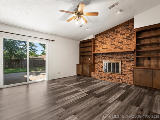 317 NE Autumn Ct, Bartlesville, OK 74006 - unfurnished living room featuring vaulted ceiling, a textured ceiling, built in features, a brick fireplace, and ceiling fan