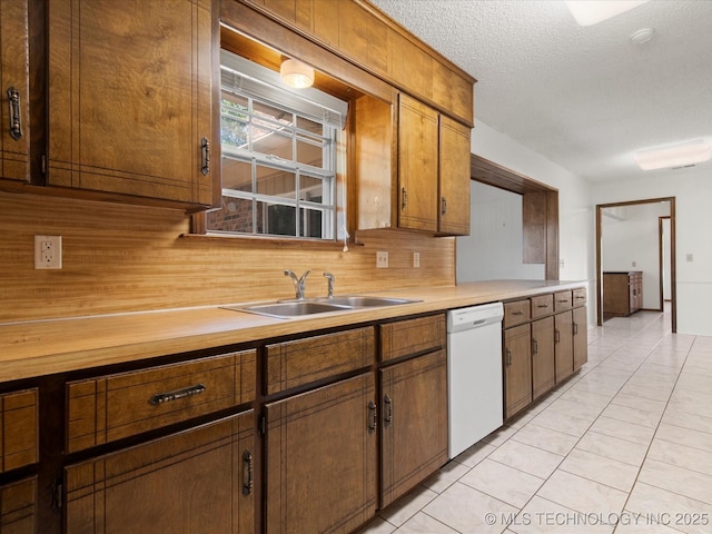 317 NE Autumn Ct, Bartlesville, OK 74006 - kitchen with white dishwasher, backsplash, light countertops, a textured ceiling, and brown cabinets
