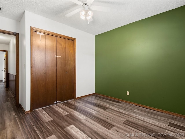 317 NE Autumn Ct, Bartlesville, OK 74006 - unfurnished bedroom with dark wood finished floors, a closet, a textured ceiling, and a ceiling fan
