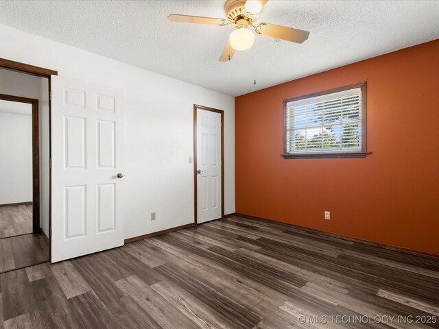 317 NE Autumn Ct, Bartlesville, OK 74006 - unfurnished bedroom featuring dark wood-style floors, a textured ceiling, and ceiling fan