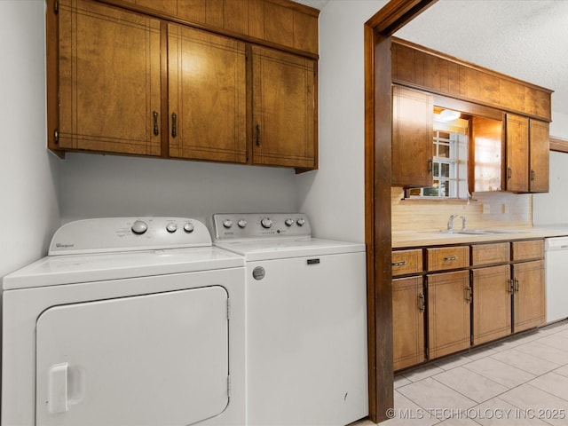 317 NE Autumn Ct, Bartlesville, OK 74006 - washroom featuring separate washer and dryer, cabinet space, and light tile patterned floors