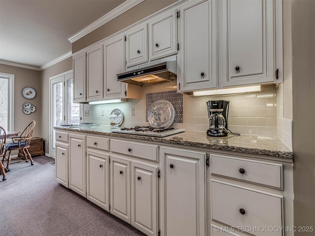 1201 Dogwood Ct, Bartlesville, OK 74006 - kitchen featuring under cabinet range hood, gas cooktop, white cabinetry, crown molding, and carpet