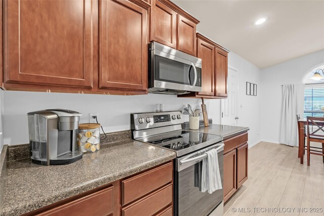 8745 S 261st E Ave, Broken Arrow, OK 74014 - kitchen featuring stainless steel appliances, dark countertops, light wood finished floors, recessed lighting, and vaulted ceiling