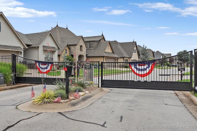 11248 S 75th Ave E, Bixby, OK 74008 - view of asphalt road with a gate, a residential view, curbs, and a gated entry